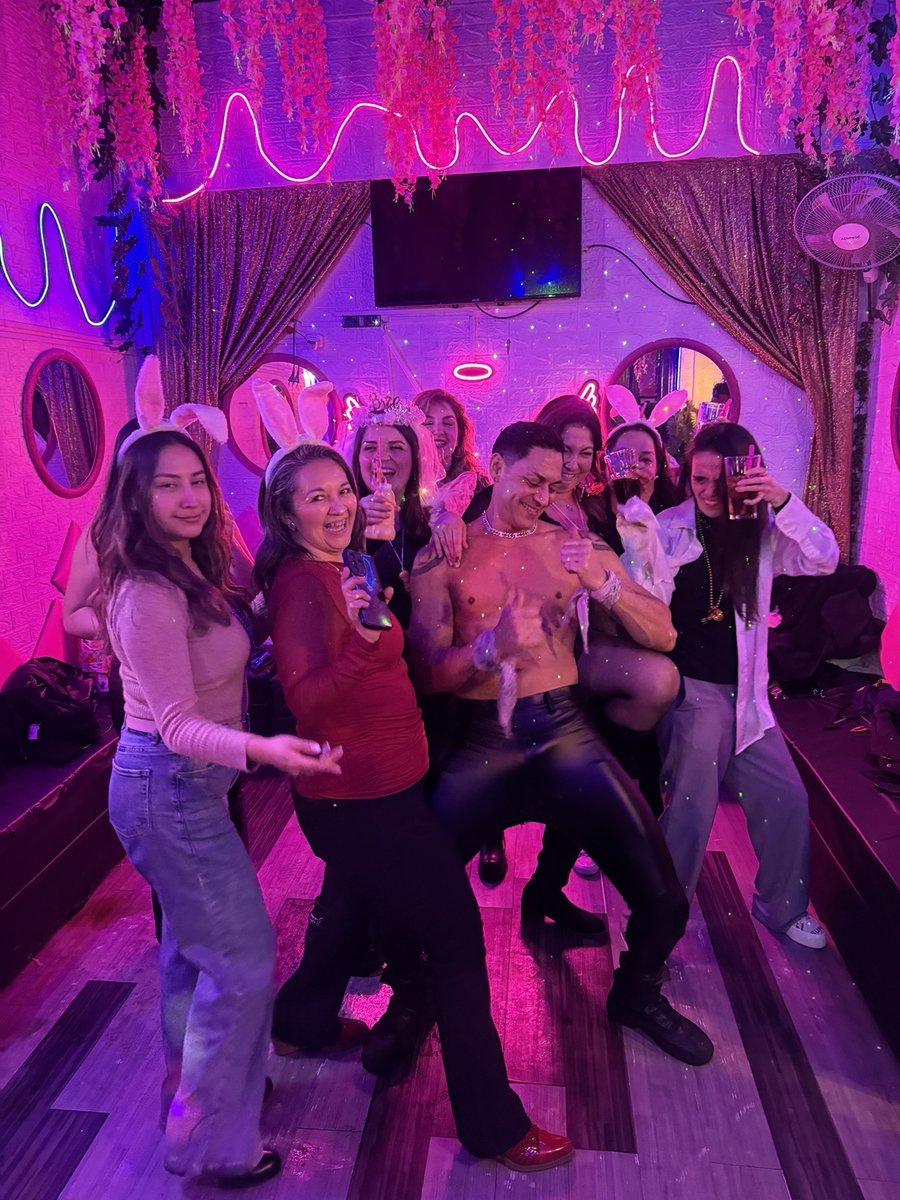Grupo de amigas bailando bajo los neones del Club de Princesas Santiago
